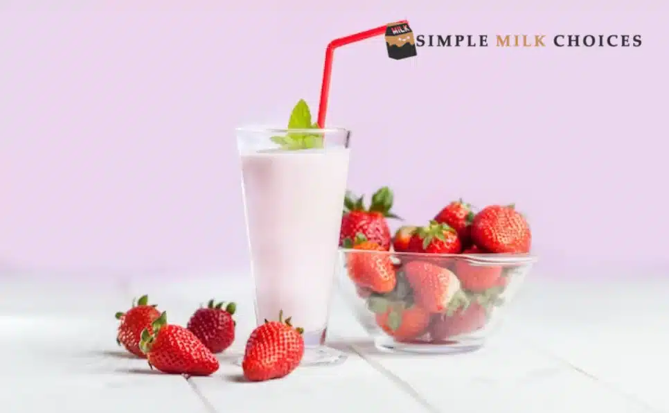 Glass of milk with ripe strawberries on a wooden table, showcasing a refreshing and healthy beverage with vibrant red fruits floating in the creamy white liquid.