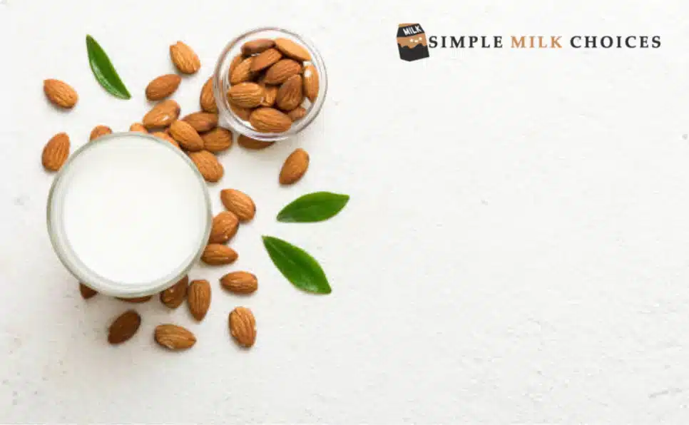 A glass of almond milk next to a pile of almonds. Text overlay reads, 'Almond Milk and Histamine: Safe for Some, but Not All. Learn more about histamine sensitivity and almond milk.